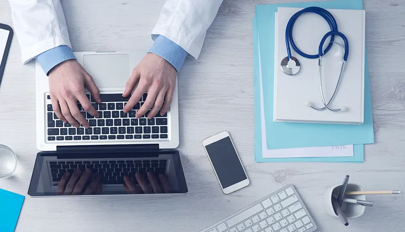 PRP Doctor making platelet rich plasma treatments notes on laptop
